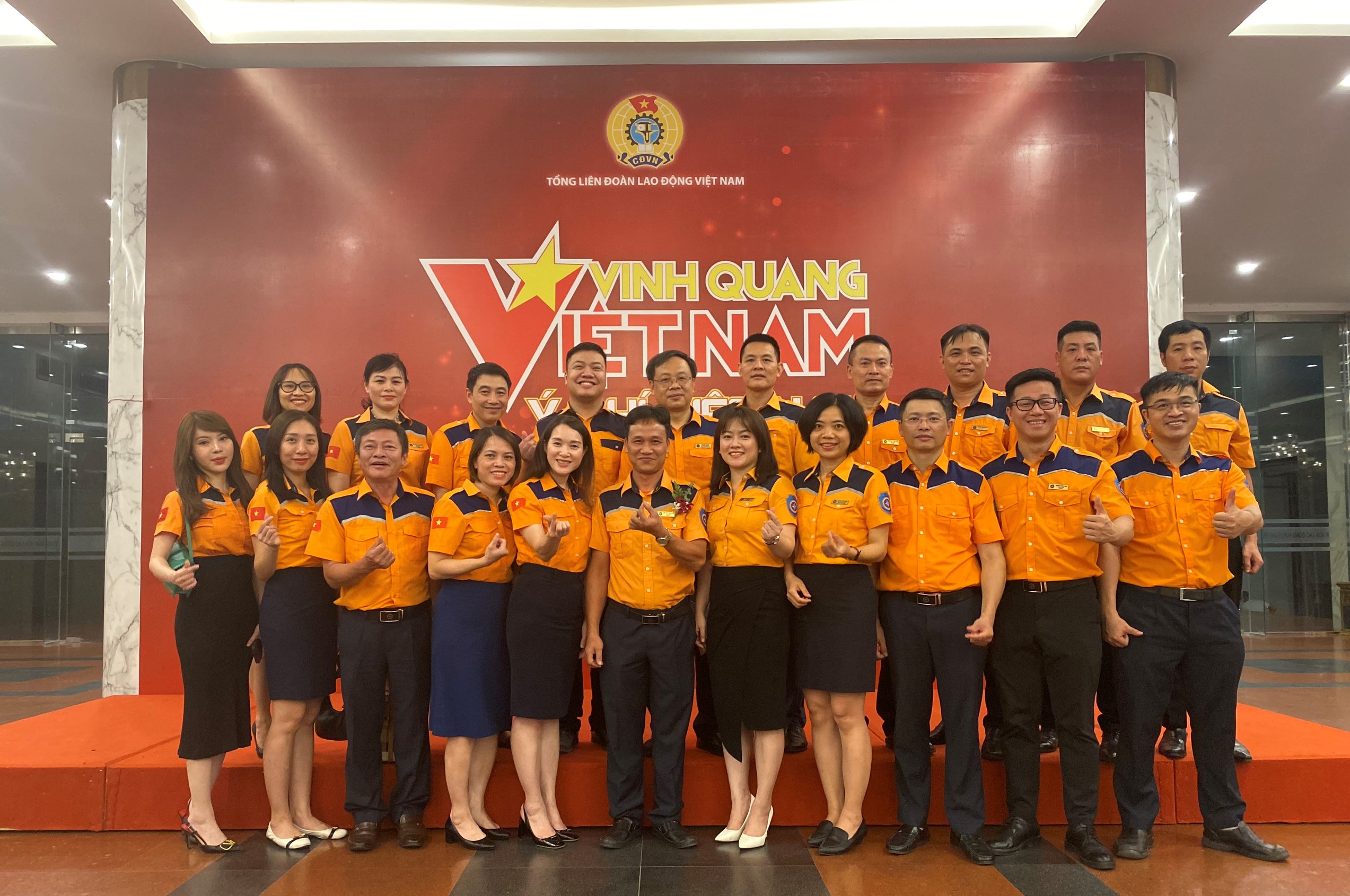 A group of people in orange shirtsDescription automatically generated