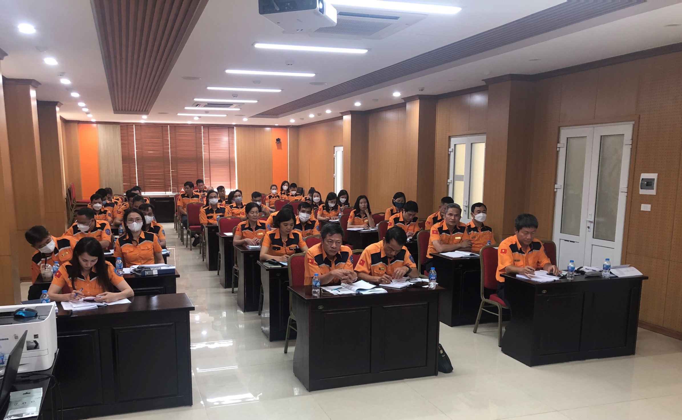 A group of people sitting at desks in a roomDescription automatically generated with medium confidence